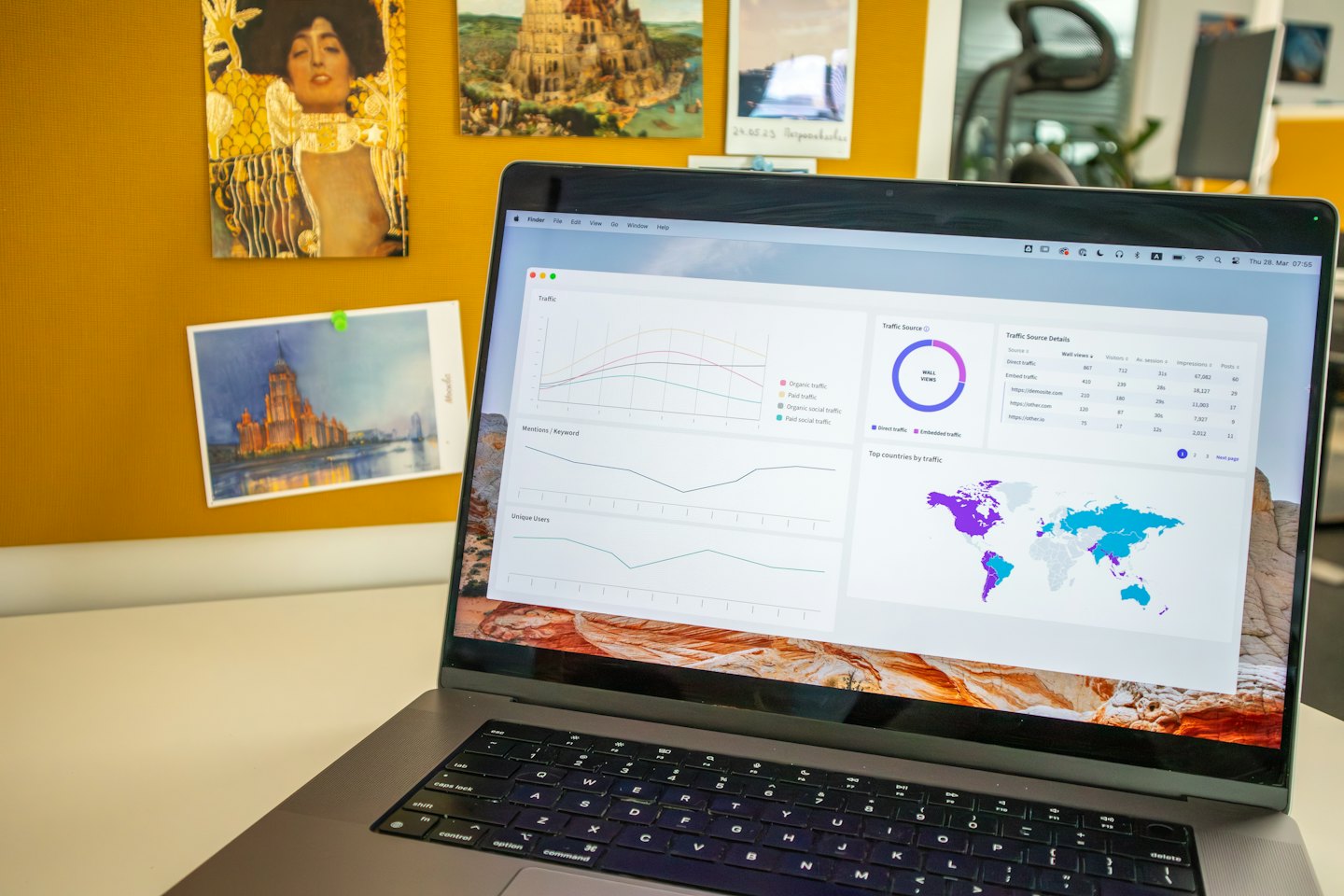 Na biurku stoi laptop z wyświetlonym pulpitem analityki danych.